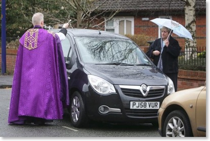 Priest blessing a car